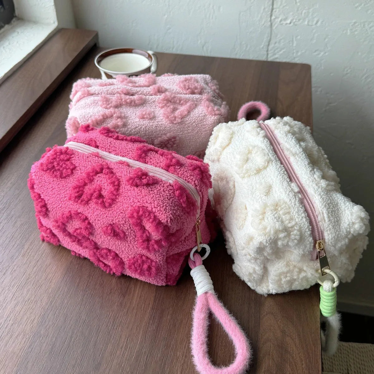 Trousse de toilette matelassée rose en tissu peluche avec imprimés cœurs, idéale pour femme et voyage