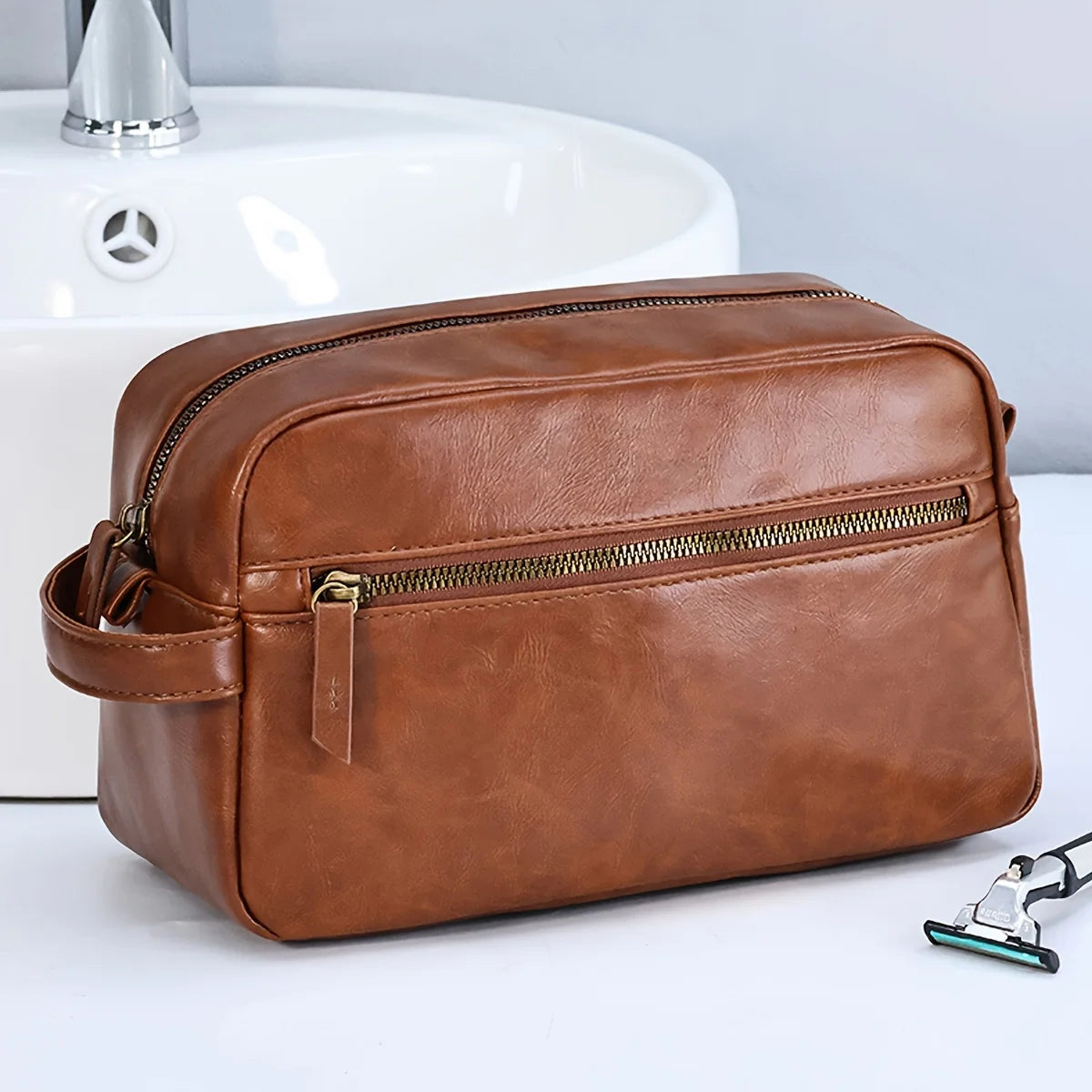 Trousse de toilette cuir marron posée sur un lavabo, accessoire élégant et fonctionnel pour les hommes soucieux de leur style en déplacement