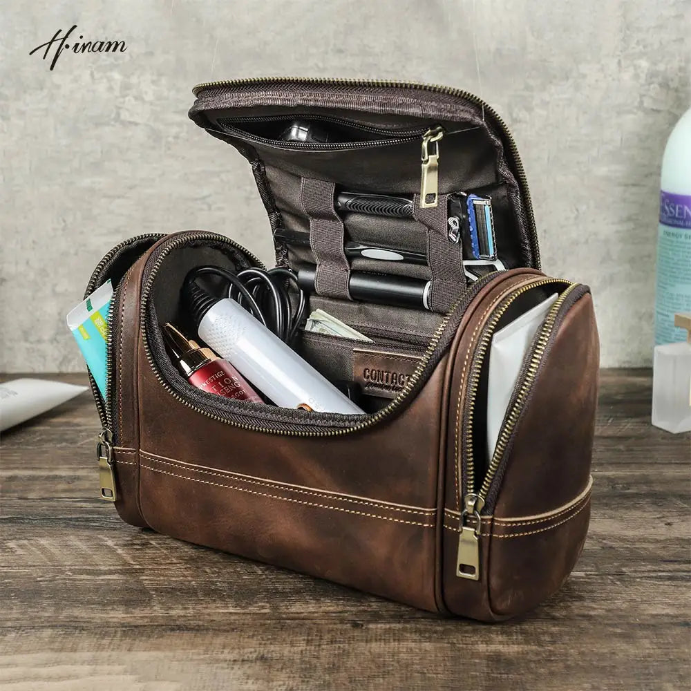 Trousse de toilette homme en cuir vintage posée ouverte sur un meuble, contenant des produits de soin, avec fermeture éclair et compartiments intérieurs